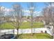 Well-kept backyard featuring green grass, mature trees, and a secure white fence at 2468 Wyndham S Pl, Columbus, IN 47203