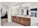 Bathroom featuring a double sink vanity, large mirror, and a view into the adjacent bedroom, offering a spacious and modern design at 2468 Wyndham S Pl, Columbus, IN 47203