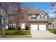 Two-story brick home featuring an attached two-car garage, landscaped yard, and a classic architectural design at 2468 Wyndham S Pl, Columbus, IN 47203