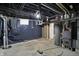 View of the unfinished basement showing the mechanical systems and black plastic covered walls at 2828 N Moreland Ave, Indianapolis, IN 46222