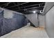 Unfinished basement featuring stair access and a partial vapor barrier at 2828 N Moreland Ave, Indianapolis, IN 46222