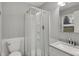 Bathroom featuring a tiled shower with glass doors, a modern vanity, and a window at 2828 N Moreland Ave, Indianapolis, IN 46222