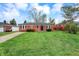 Classic brick home with a spacious front lawn under a partly cloudy sky at 2828 N Moreland Ave, Indianapolis, IN 46222