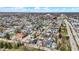 An aerial view showcasing a neighborhood with a variety of colorful homes, a nearby commercial area, and clear skies at 305 Sanders St, Indianapolis, IN 46225