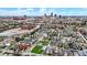 An aerial view of a neighborhood next to a cityscape, featuring colorful homes and commercial buildings under a blue sky at 305 Sanders St, Indianapolis, IN 46225