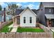 Charming home featuring a freshly-cut lawn, a decorative picket fence, and a cozy porch entryway at 305 Sanders St, Indianapolis, IN 46225