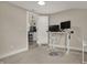 This office includes neutral walls, a computer desk, and a partial view into the kitchen at 305 Sanders St, Indianapolis, IN 46225