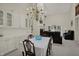 Dining room with chandelier, white cabinets and view of fireplace with sofas at 36 Palomino Ct, Zionsville, IN 46077