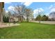 Expansive backyard featuring a lush green lawn, mature trees, and a swing set for outdoor enjoyment at 3748 Pawnee Trl, Columbus, IN 47203