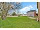 Spacious backyard with lush green lawn, mature trees, and a swing set for outdoor enjoyment at 3748 Pawnee Trl, Columbus, IN 47203