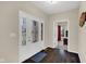Inviting foyer with decorative glass front door, dark wood floors, and view to bedroom at 3748 Pawnee Trl, Columbus, IN 47203