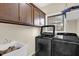 Well-equipped laundry room featuring modern washer, dryer, and ample cabinet space at 3748 Pawnee Trl, Columbus, IN 47203