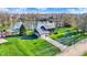 Stunning aerial view of a home with a pool, surrounded by lush greenery and a tranquil lake at 3771 Lakewood Dr, Greenfield, IN 46140