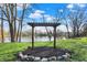 Decorative backyard pergola surrounded by lush greenery and rocks, creating a serene outdoor retreat at 3771 Lakewood Dr, Greenfield, IN 46140