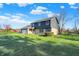 Beautiful home with a spacious front yard, brick accents, and a backdrop of mature trees and blue sky at 3771 Lakewood Dr, Greenfield, IN 46140