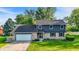 Charming two-story home with a brick and vinyl exterior, a well-manicured lawn, and an attached two-car garage at 3771 Lakewood Dr, Greenfield, IN 46140