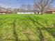 Large backyard with lush green grass and mature trees offering plenty of space at 3913 Eastern Dr, Anderson, IN 46012