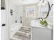 Updated bathroom with gray walls, marble-look tile, and ample counter space with a green plant at 3913 Eastern Dr, Anderson, IN 46012
