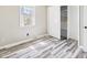 Bedroom featuring gray walls, vinyl plank flooring, window, and closet for plenty of storage at 3913 Eastern Dr, Anderson, IN 46012