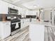 Modern kitchen featuring white cabinets, stainless steel appliances, and stylish backsplash, ideal for cooking enthusiasts at 3913 Eastern Dr, Anderson, IN 46012