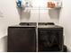 Laundry room with dark, modern washer and dryer under a shelf with detergents at 4068 Bozeman Way, Bargersville, IN 46106
