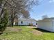 A cozy backyard featuring a well-maintained home, a detached garage, and a lush green lawn at 414 Glendale Dr, Columbus, IN 47201