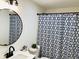 Bathroom features modern fixtures, round mirror, sleek vanity, and decorative shower curtain at 414 Glendale Dr, Columbus, IN 47201