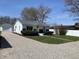 Charming single-story home with well-manicured lawn and gravel driveway, located near a detached garage at 414 Glendale Dr, Columbus, IN 47201