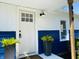 A lovely front door with plants, a porch light, and partial address numbers of the home at 414 Glendale Dr, Columbus, IN 47201