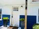 Close up of the home's entry featuring a white front door, plants, and partial home address at 414 Glendale Dr, Columbus, IN 47201