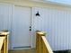 Close up of the entry door of a detached garage featuring a wooden deck and exterior lighting at 414 Glendale Dr, Columbus, IN 47201