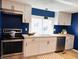 Bright kitchen features modern cabinets, stainless steel appliances, wood countertops and beautiful blue accent wall at 414 Glendale Dr, Columbus, IN 47201