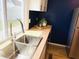 Bright kitchen features modern cabinets, stainless steel appliances, wood countertops and beautiful blue accent wall at 414 Glendale Dr, Columbus, IN 47201