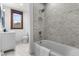 Bathroom features a modern vanity, subway tile in shower over tub, and hexagon tile flooring at 434 E New York St, Indianapolis, IN 46202