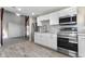 This kitchen features white cabinets, stainless steel appliances, with wood look tile at 434 E New York St, Indianapolis, IN 46202