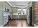 Modern kitchen showcasing green cabinetry, stainless steel appliances, and hardwood floors at 434 E New York St, Indianapolis, IN 46202