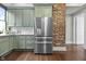 Updated kitchen with stainless steel refrigerator and exposed brick wall at 434 E New York St, Indianapolis, IN 46202