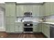 Well-equipped kitchen with stainless steel appliances and custom green cabinets at 434 E New York St, Indianapolis, IN 46202