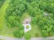 Aerial view of a brick house with a long circular driveway, surrounded by a green lawn, pool, and lots of trees at 4743 Little Hurricane Rd, Martinsville, IN 46151