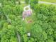 Aerial view of a brick house with a long circular driveway, surrounded by a green lawn, pool, and lots of trees at 4743 Little Hurricane Rd, Martinsville, IN 46151