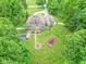 Aerial view of a brick house, backyard with pool, playground, and a fire pit surrounded by many trees at 4743 Little Hurricane Rd, Martinsville, IN 46151