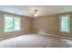 Spacious bedroom featuring two large windows for ample natural light and neutral carpet and walls at 4743 Little Hurricane Rd, Martinsville, IN 46151