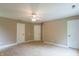 Bright bedroom featuring neutral carpet and walls, a ceiling fan, and multiple closets and doors at 4743 Little Hurricane Rd, Martinsville, IN 46151