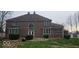 Back exterior elevation of the brick home featuring large windows and mature landscaping at 4743 Little Hurricane Rd, Martinsville, IN 46151