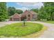 Expansive brick home with mature landscaping, multiple garages, a circular driveway, and a charming fountain at 4743 Little Hurricane Rd, Martinsville, IN 46151