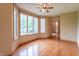 A living room with hardwood floors, neutral walls, a ceiling fan, and bay windows with green views at 4743 Little Hurricane Rd, Martinsville, IN 46151