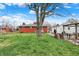 Expansive backyard featuring a classic brick home, detached garage, and mature shade tree at 5440 Maplewood Dr, Indianapolis, IN 46224