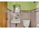 A classic bathroom with a white sink, toilet, pink tiles, and a mirrored medicine cabinet at 5440 Maplewood Dr, Indianapolis, IN 46224