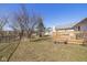 Expansive backyard view showcasing the well maintained lawn and serene pond with mature trees at 546 Treyburn Lakes Way, Indianapolis, IN 46239