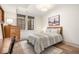 Neutral bedroom features a bright window, light hardwood floors, and decorative landscape art at 583 Exmoor Dr, Carmel, IN 46032